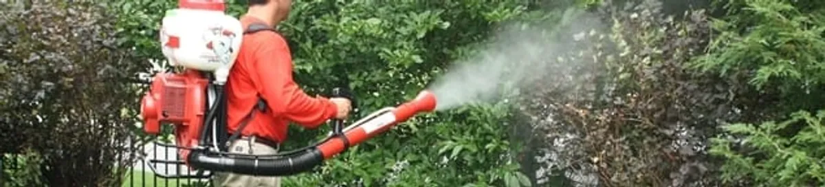 Mosquito control technician fogging shrubs and landscaping for mosquito treatment in Colorado Springs, CO